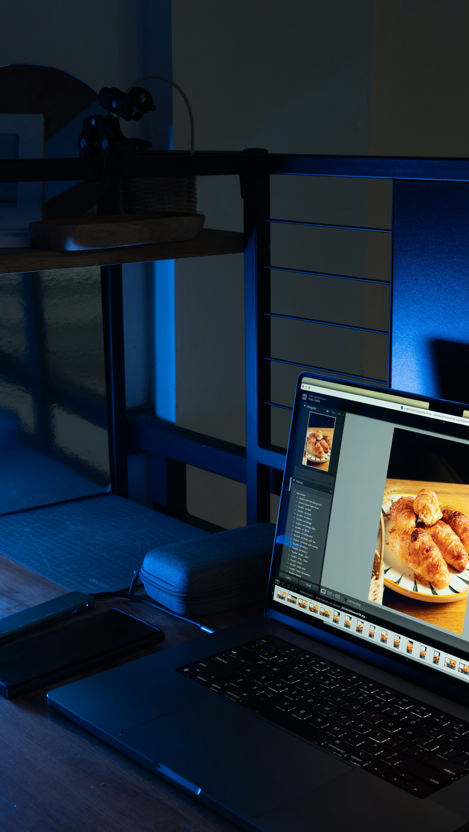 Laptop displaying baked goods on a wooden table.